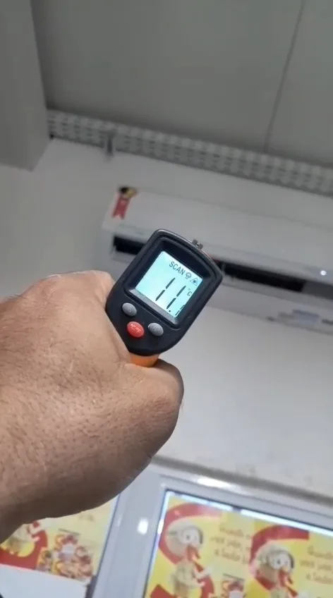 Termômetro infravermelho medindo a temperatura na saída do ar após o serviço